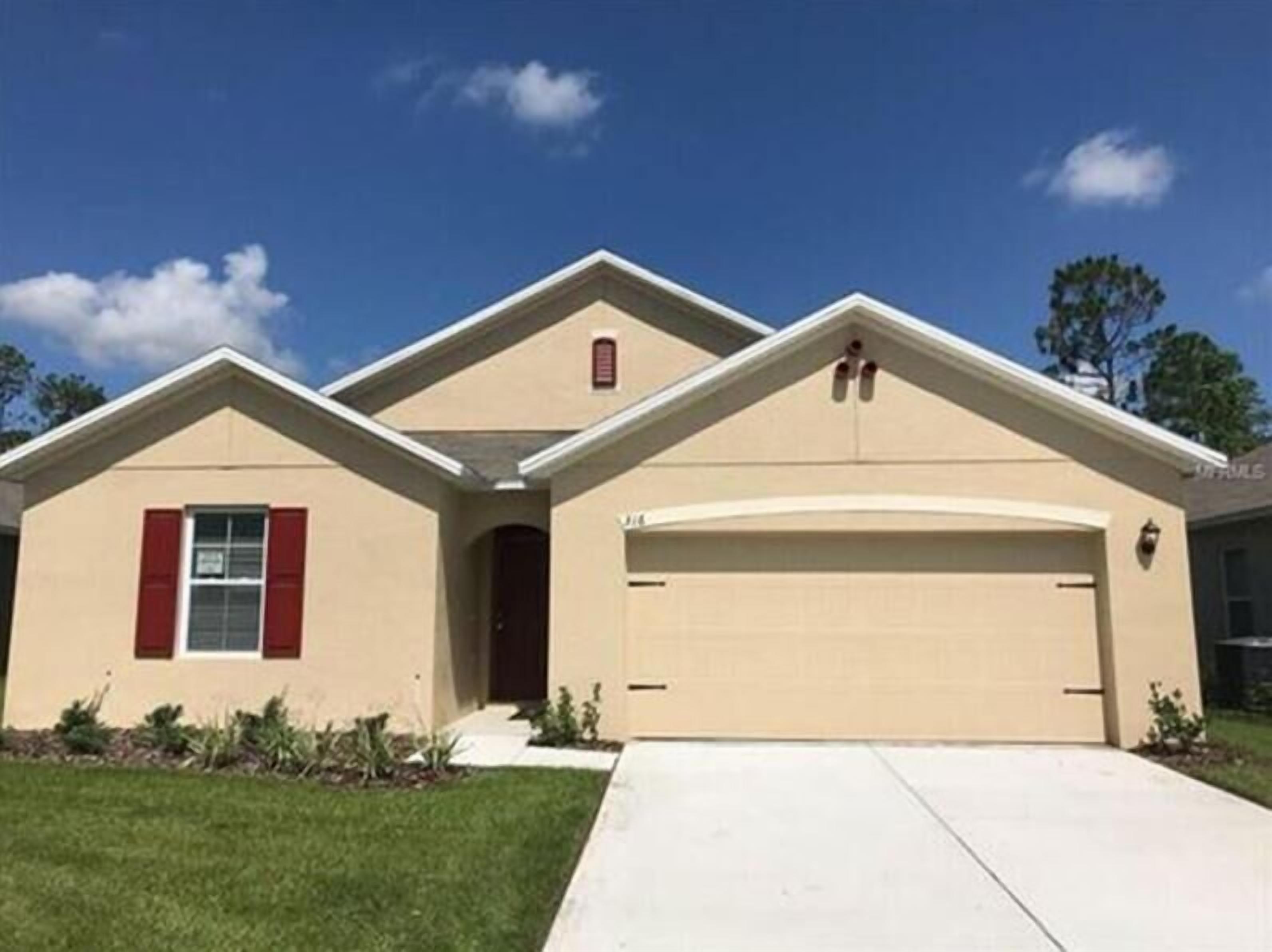 A single-story house with a beige exterior, a red door, and a garage.