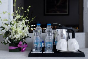 Ein Tablett mit Wasserflaschen, zwei weißen Tassen und einem Wasserkocher.