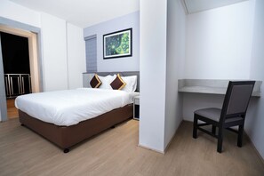 Een moderne hotelkamer met een bed, een bureau en een stoel.