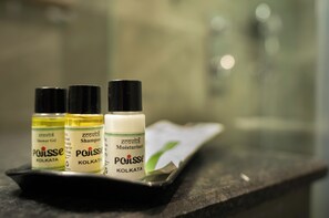 Trois bouteilles de produits de la marque Poisse Kolkata sont présentées sur un plateau.