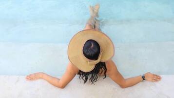 Una persona recostada junto a la piscina, con vista despejada al agua.