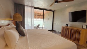 A modern hotel room with a large bed, a TV, a wooden cabinet, and a balcony with a view. - Amainah Bacalar (Bacalar)
