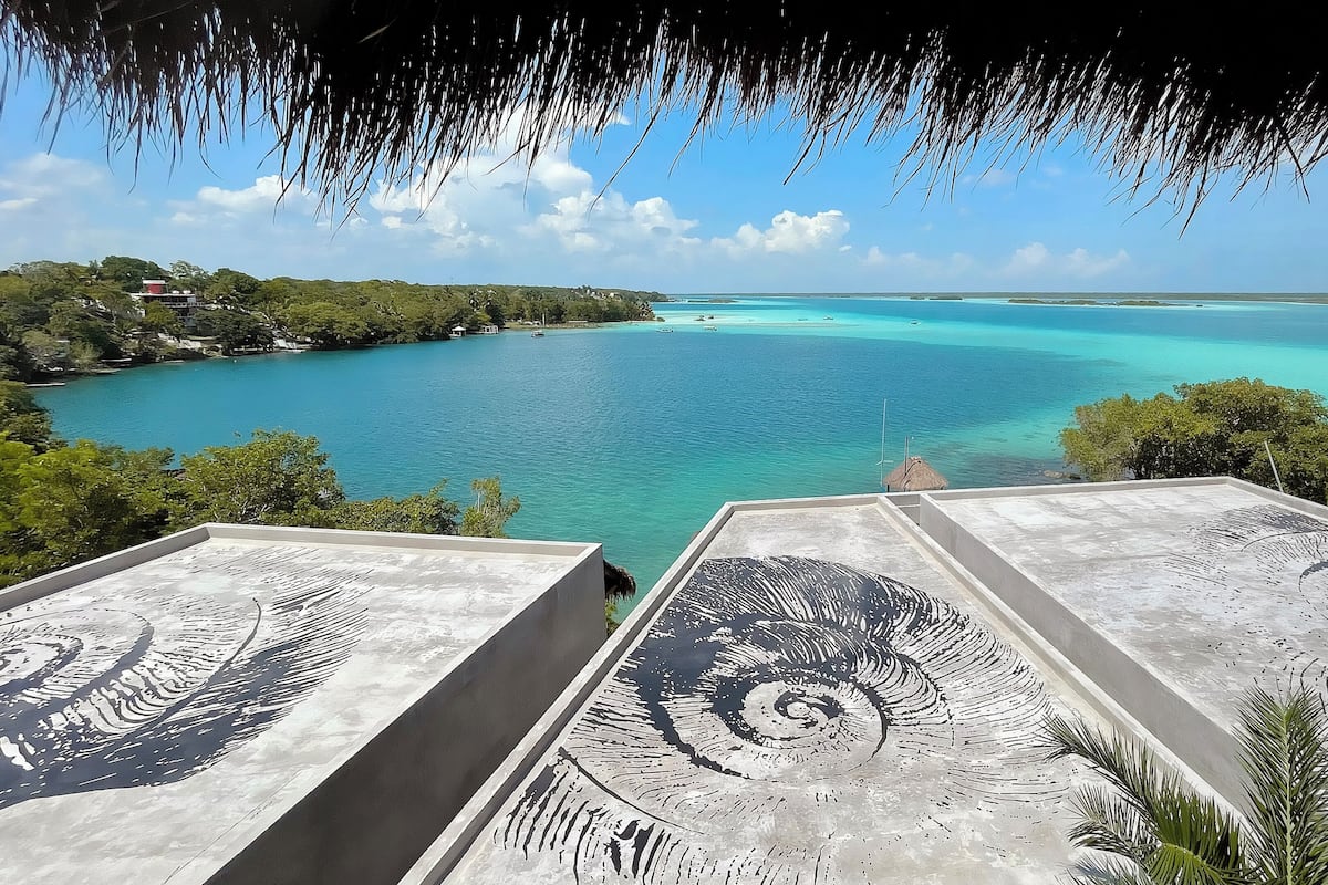 Vista de um terraço no topo, com vista para um mar azul-turquesa e céu limpo.