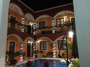 A courtyard with a pool, arches, and balconies decorated with lights. - Hotel Casa Sofia Tulum (Tulum)