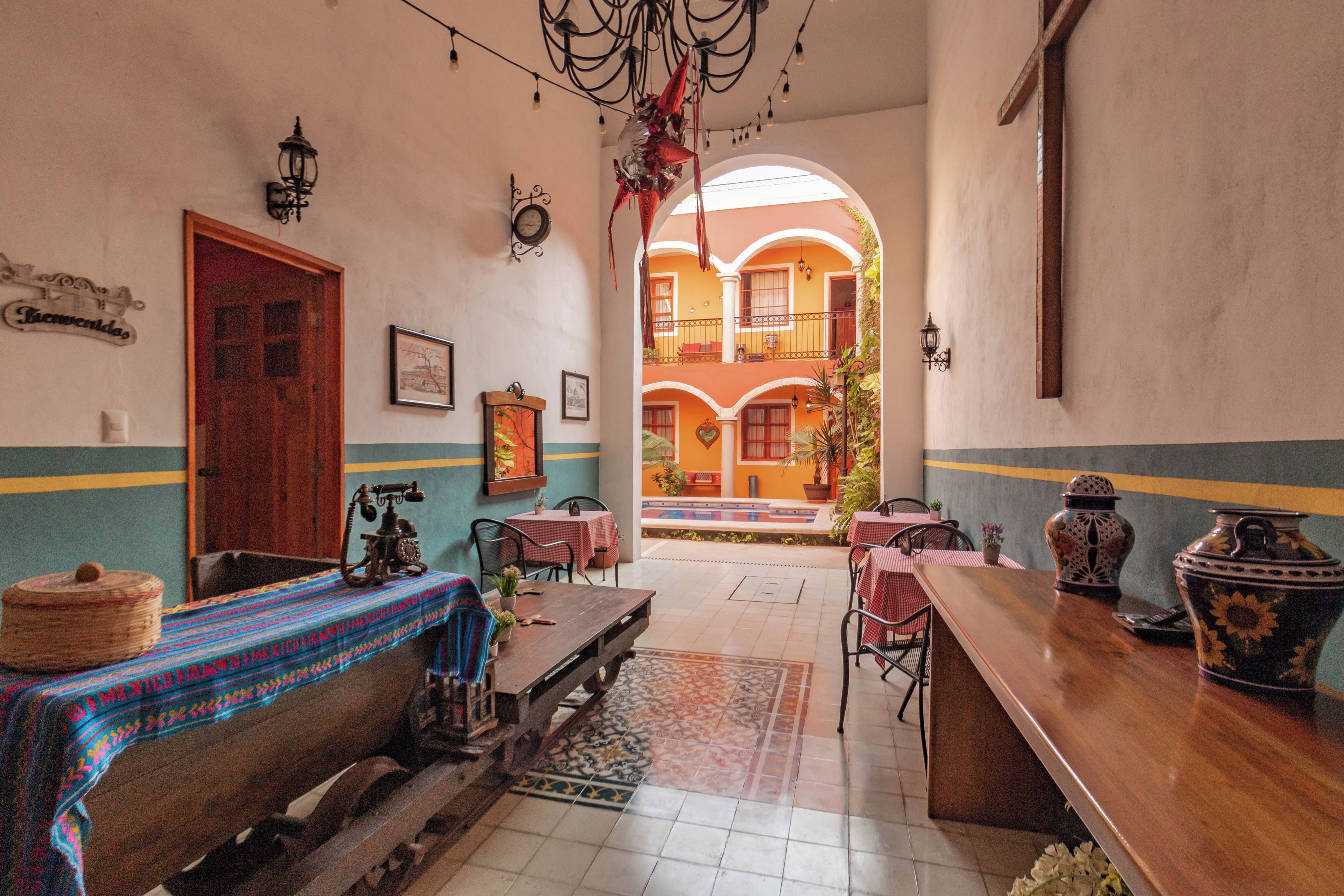 Uma hospedaria tradicional com um banco de madeira, mesas e um vaso grande no balcão.