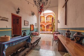 A traditional inn with a wooden bench, tables, and a large vase on the counter. - Hotel Casa Sofia Tulum (Tulum)
