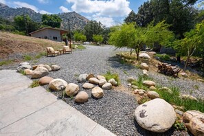 A gravel path leading to a building with outdoor seating and a mountain backdrop. - Sequoia Park Retreat: Patio, Fire Pit, Game Area (Three Rivers)