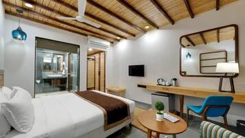 A hotel room with a bed, a desk, a chair, a television, and a mirror.