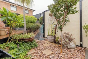 A garden with potted plants, a small pond, and a pathway.