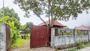 A gated property with a wooden gate, a concrete wall, and a metal gate with a sign. - Oyo 91830 Hotel Gemilang 2 (Sembalun Lawang)