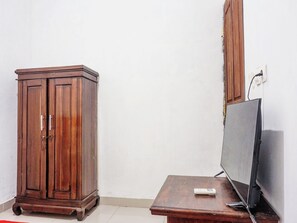 A room with a wooden cabinet and a television on a wooden table. - Oyo 91654 Bintang Residence (Jakarta)