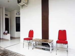 Una stanza con due sedie rosse e un tavolo di legno.
