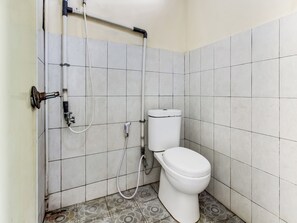 A bathroom with a toilet, a shower, and a handwashing station. - Spot On 91374 Asia Stay Semarang (Semarang)