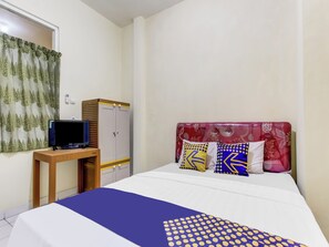 A hotel room with a bed, a television on a small table, a wardrobe, and a window with curtains. - Spot On 91374 Asia Stay Semarang (Semarang)