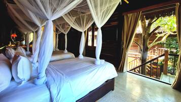 A four-poster bed with a canopy, a wooden floor, and a view of a wooden deck and trees.