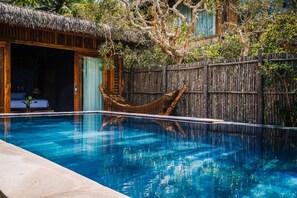 A swimming pool with a wooden deck, a thatched-roof structure, and a bamboo hammock. - Ocean Bay Resort & Spa Phu Quoc (Phu Quoc)