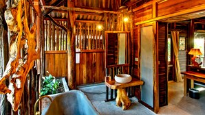 A rustic cabin interior with wooden walls, a stone sink, and a hanging light fixture. - Ocean Bay Resort & Spa Phu Quoc (Phu Quoc)