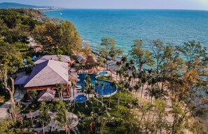 Un complexe hôtelier doté d’une grande piscine, d’une plage et offrant une vue sur la mer.