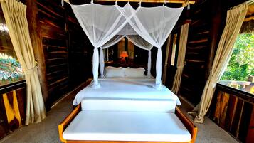 A bed with a canopy in a wooden room with curtains.