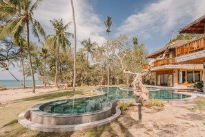 A pool area with a curved design, surrounded by palm trees and a beach. - Ocean Bay Resort & Spa Phu Quoc (Phu Quoc)