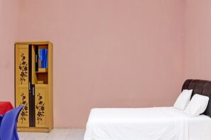 Una habitación con una cama, un armario y una silla.