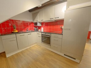 Eine Küche mit Einbauofen, Mikrowelle und Kühlschrank.