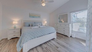 A bedroom with a bed, nightstands, a dresser, a ceiling fan, and a window with blinds. - Legacy Park Executive Gamesroom (Davenport)