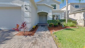 A residential building with a garage, a front entrance, and a landscaped driveway. - Legacy Park Executive Gamesroom (Davenport)