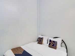 A neatly made bed with white bedding and two decorative pillows with geometric patterns. - Spot On 91834 Sg 99 Homestay Syariah (Pekanbaru)