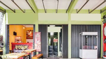 Ein Restaurant mit grün-weißer Farbgebung, das eine Theke, einen Sitzbereich und ein Servicefenster bietet.