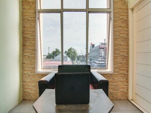 A room with a large window, a black chair, and a table. - Spot On 91834 Sg 99 Homestay Syariah (Pekanbaru)