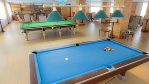 A pool table with balls, a bar area, and seating in a room with wooden walls and ceiling. - Araliya Red (Nuwara Eliya)