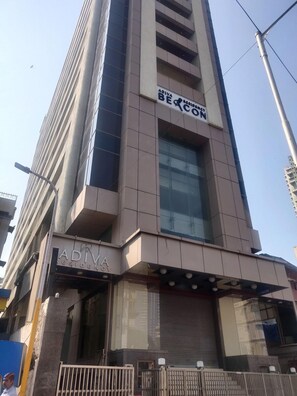 A tall building with a sign for 'ADIVA RESIDENCY' and a large window. - Adiva Residency Beacon,mumbai (Mumbai)