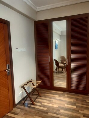 A room with wooden flooring, a wooden door, and a wooden table. - Adiva Residency Beacon,mumbai (Mumbai)