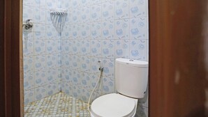 A bathroom with a toilet, shower, and patterned tiles.