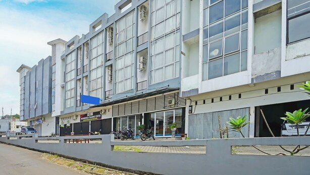 A multi-story building with large windows, a sign for a training center, and parked motorcycles.