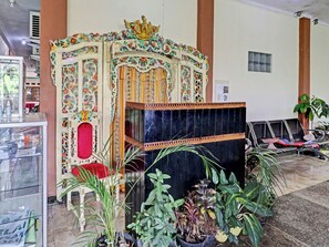Una zona de recepción con una entrada decorativa, un área de estar y plantas en macetas.