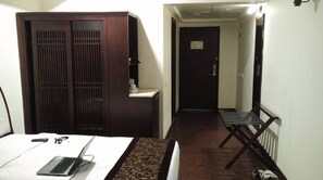 A hotel room with a bed, a desk with a laptop, a wardrobe, and a small table with a chair. - The Fern Residency Asansol (Asansol)
