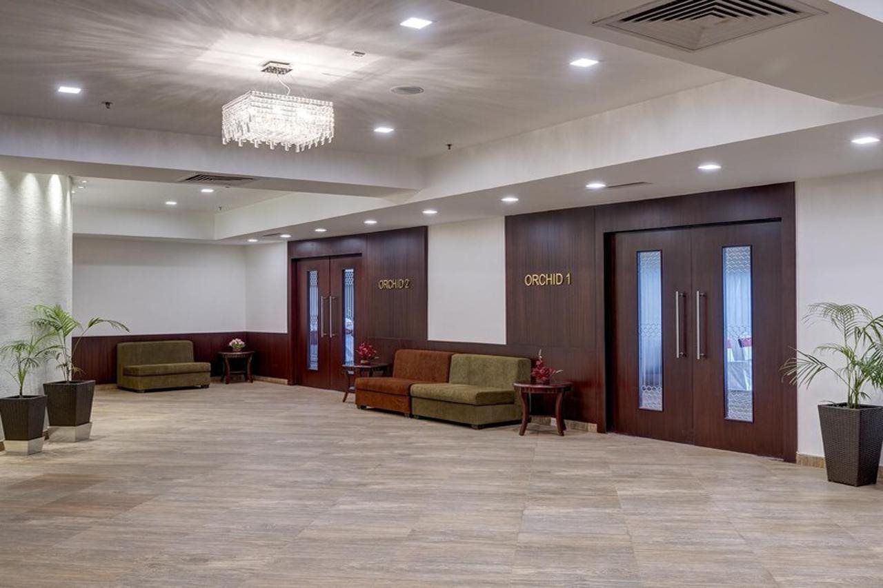 A reception area with a chandelier, two sofas, and two doors labeled 'ORCHID 1' and 'ORCHID 2'.