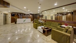 A lobby with a reception desk, green sofas, a white coffee table, and a marble floor. - The Fern Residency Asansol (Asansol)