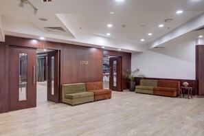 A reception area with a wooden reception desk, two sofas, a potted plant, and a sign that reads 'LOTUS'. - The Fern Residency Asansol (Asansol)
