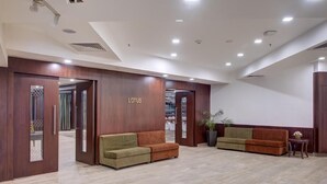 A reception area with a wooden reception desk, two sofas, a potted plant, and a sign that reads 'LOTUS'. - The Fern Residency Asansol (Asansol)