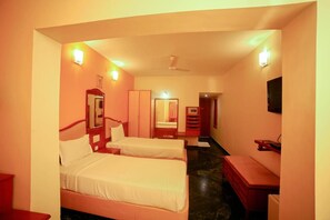 A hotel room with two beds, a desk, a mirror, a wardrobe, and a television. - Sterling Arunai Anantha Tiruvannamalai (Tiruvannamalai)