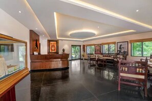 A hotel lobby with a reception desk, seating area, and large windows. - Sterling Arunai Anantha Tiruvannamalai (Tiruvannamalai)