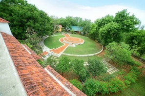 A courtyard with a circular garden, a small building, and surrounding trees. - Sterling Arunai Anantha Tiruvannamalai (Tiruvannamalai)