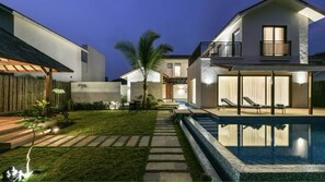 A modern house with a swimming pool, a covered patio, and a well-maintained lawn. - U Tropicana Resort & Spa (Alibag)