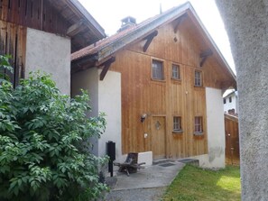 A wooden building with a sloped roof, a large door, and a small window. - Tga Clavo°, (Filisur), 117 by Interhome (Filisur)