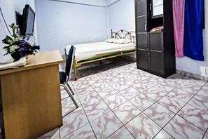 A room with a bed, a desk, a TV, and a wardrobe. - Oyo 91757 Surya Hotel (Watansoppeng)