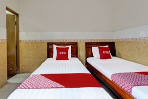 A hotel room with two beds, each with a red and white bedspread and matching pillows. - Hotel Srikandi Kalasan (Kalasan)