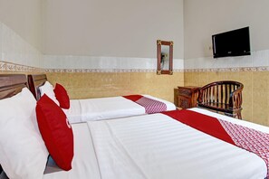 A hotel room with two beds, a television, a wooden chair, and a decorative mirror. - Hotel Srikandi Kalasan (Kalasan)